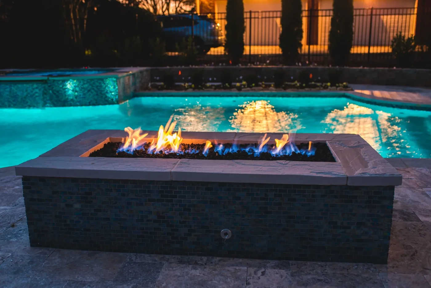 Glass tile linear fire pit with full pool visible at Tarkington Residence