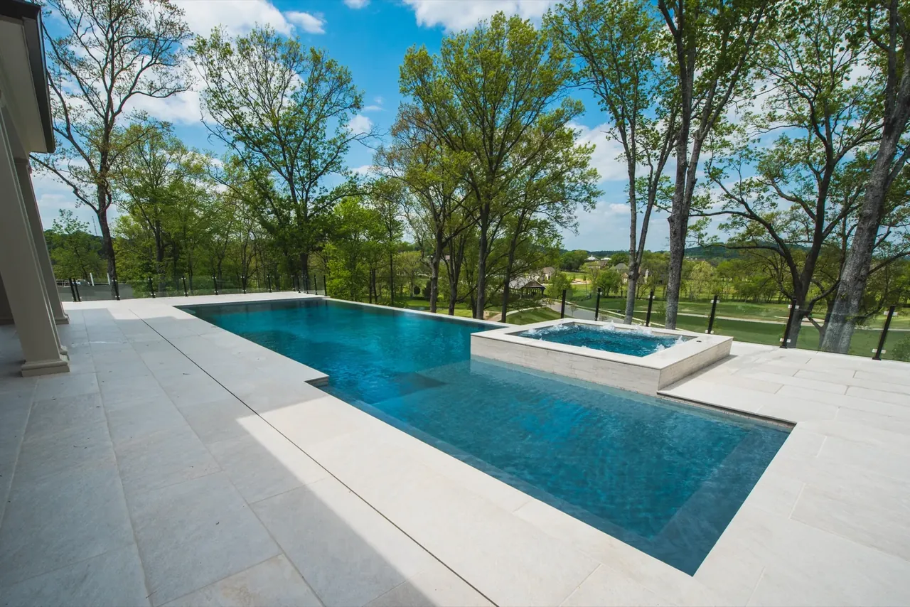 Sleek modern gunite pool with elevated spa hot tub and wooded views in Nashville