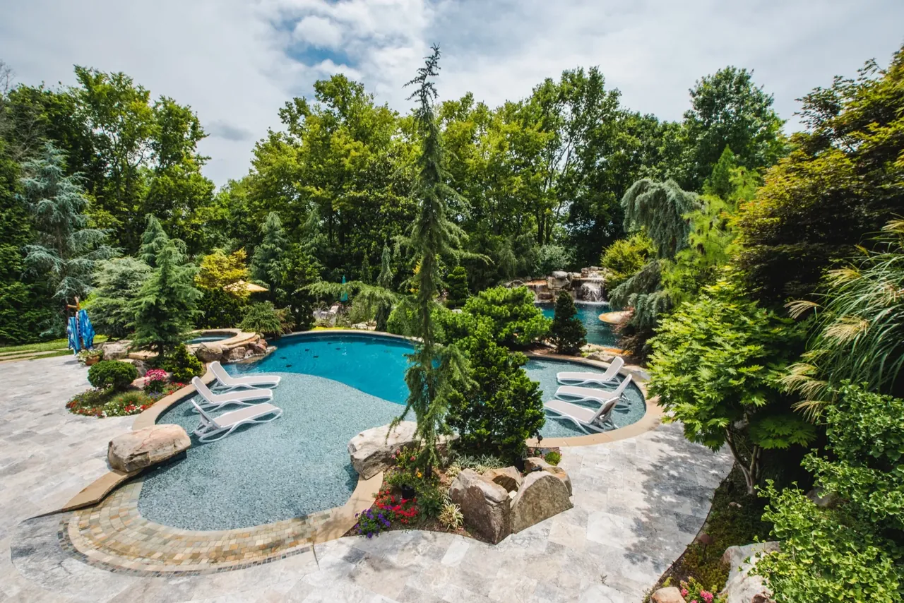 Lush freeform pool with natural rock waterfall and tropical landscaping in Nashville